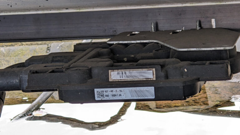Micro-omvormer is met parkers opgehangen aan het aluminium profiel van het paneel.